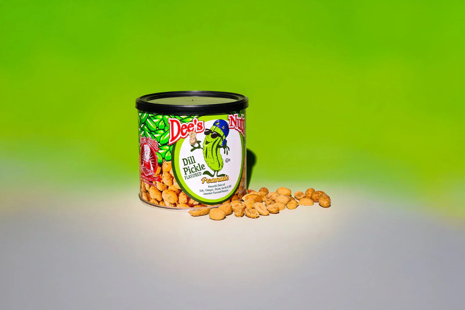 Can of Dee’s Dill Pickle Peanuts with peanuts spilled in front on a bright green background